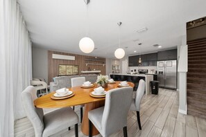 A modern kitchen with a central island, built-in appliances, and pendant lighting.