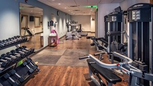 Une salle de sport équipée de machines de cardio, de poids libres et de machines de musculation.