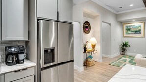 Une cuisine moderne dotée d’appareils électroménagers en acier inoxydable et d’une machine à café posée sur le plan de travail.