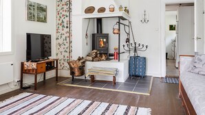 A cozy living room with a fireplace, a television, and a comfortable seating area. - Sjödrömmen by Interhome (Hudiksvall)