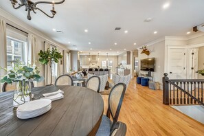 Open Concept Dining Area | Round Table Open to Living Room with Smart TV and Kitchen | Unit 2 — Second Floor of Building — Two-Level Unit
