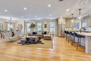 Open Concept Living Room | Sectional Sofa and Accent Chairs Open to Kitchen Island with Bar Seating for Four | Unit 2 — Second Floor of Building — Two-Level Unit