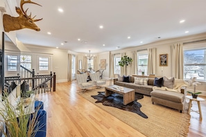 Open Concept Living Room | Smart TV with Sectional Sofa, Open to Dining Area and Interior Staircase | Unit 2 — Second Floor of Building — Two-Level Unit