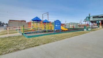 Un parque infantil con juegos de colores y un cartel que dice 'Pearl Foundation Welcome Miracle'.