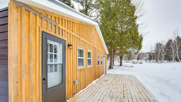 A wooden cabin with a deck, a door, and windows. - 2 Ponds & Trail Access: Peaceful Cabin in Calumet! (Calumet)