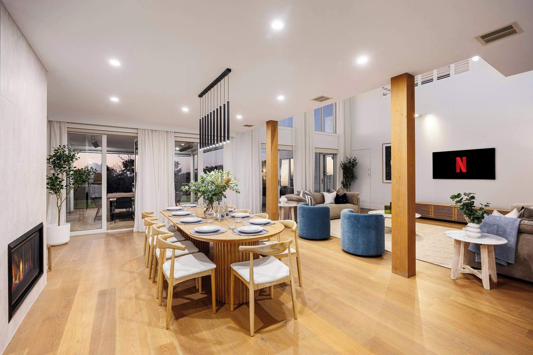 Un espace repas moderne avec une longue table, des chaises et une cheminée.