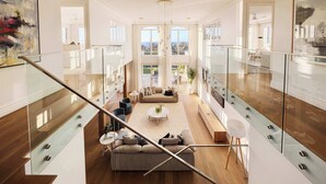 A spacious living area with a high ceiling, a glass railing, and a view of the outdoors. - Mount Martha Manor Indoor Pool & Ocean Views (Mount Martha)