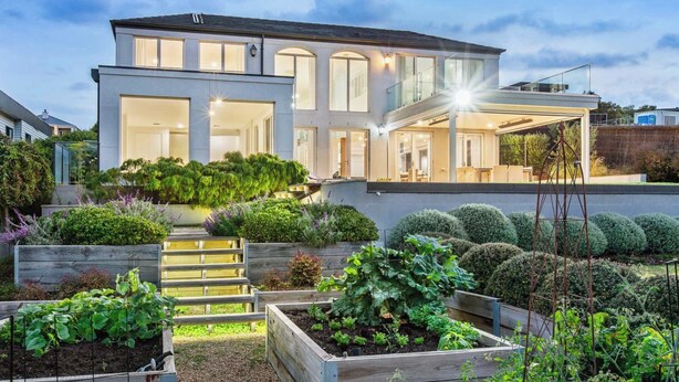A modern two-story house with a covered patio, a well-maintained garden with raised beds, and a clear view of the surrounding area. - Mount Martha Manor Indoor Pool & Ocean Views (Mount Martha)