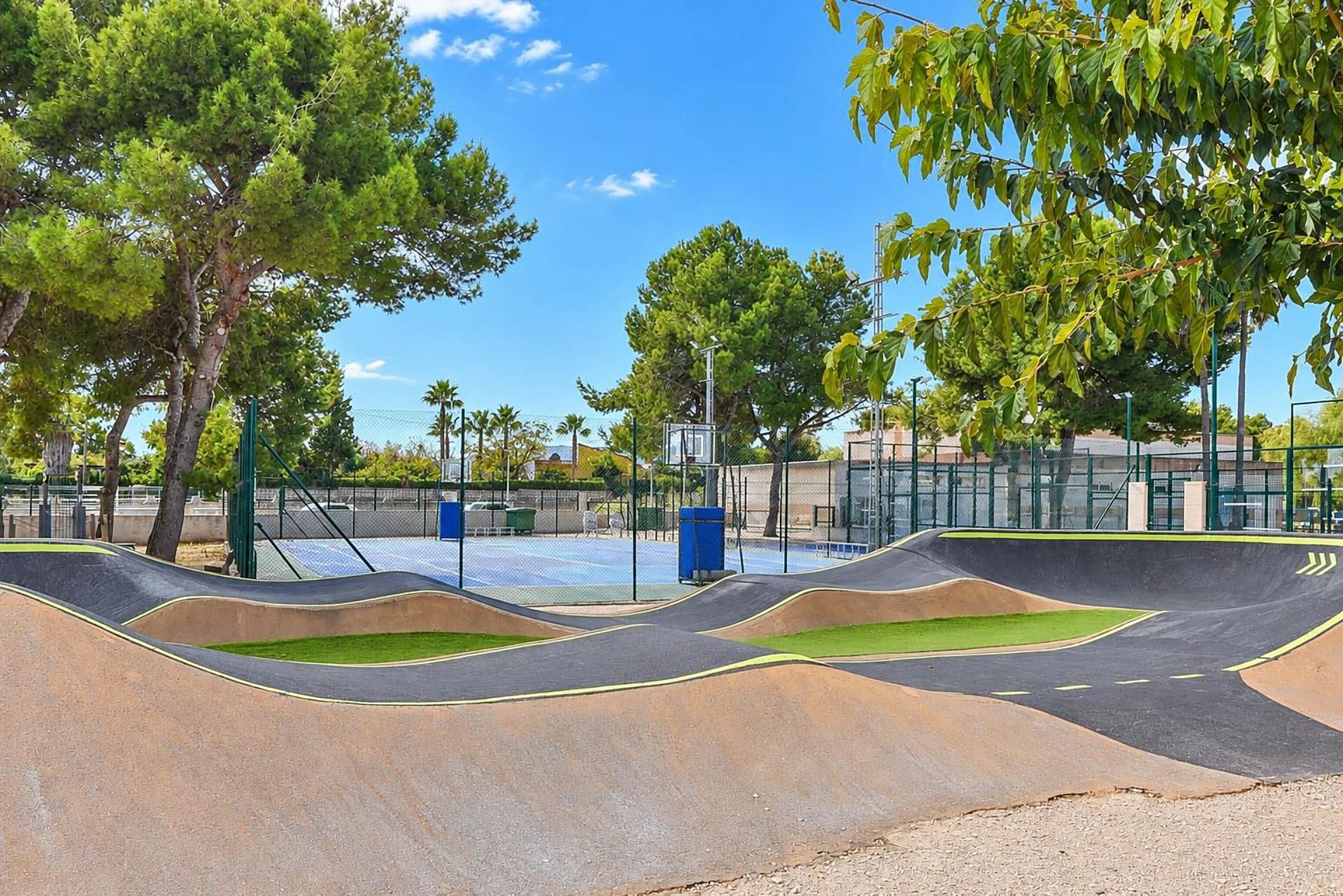 A skate park with ramps and a basketball court.