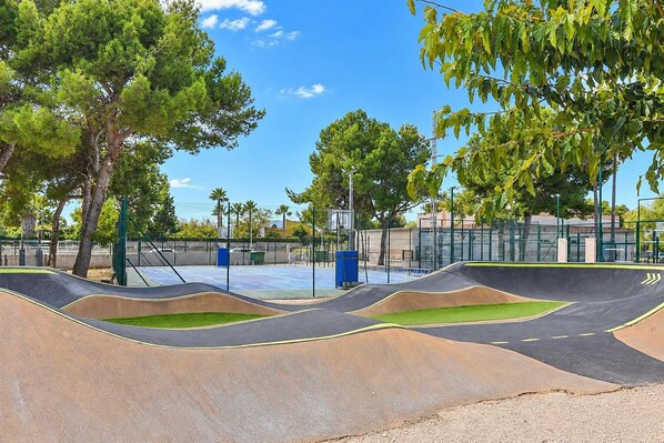 A skate park with ramps and a basketball court.