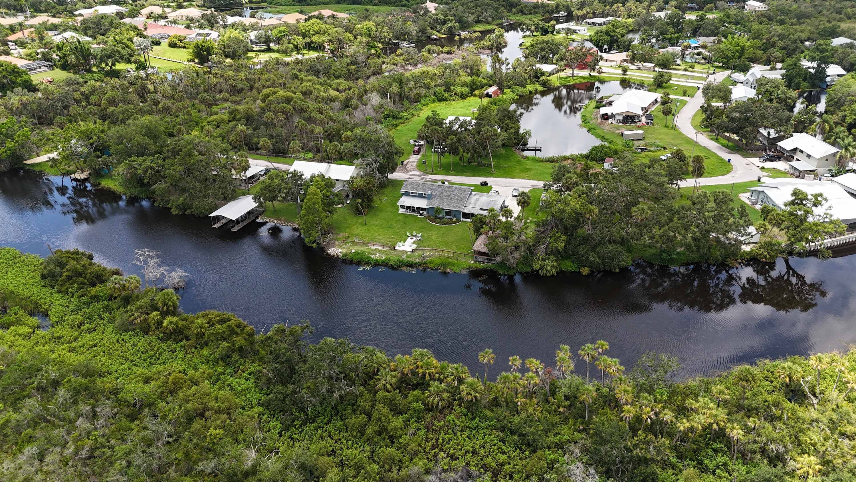A residential area with a river, houses, and a boat dock.