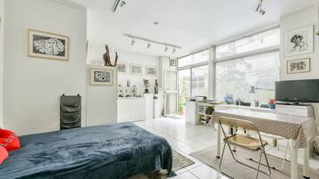 Een moderne slaapkamer met een bed, bureau en televisie.