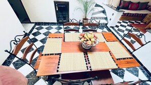 A dining area with a checkered floor, a round wooden table with a fruit bowl, and chairs with metal legs. - TYPICAL RIAD HOUSE MARRAKECH G7 - N51 (Marrakech)
