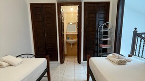 A hotel room with two beds, a bathroom with a sink and mirror, and a balcony with a railing. - TYPICAL RIAD HOUSE MARRAKECH G7 - N51 (Marrakech)