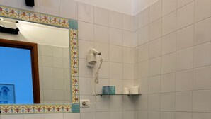 Un baño con lavamanos, bidé, inodoro y un espejo con marco decorativo.