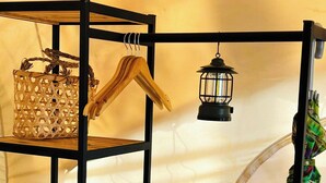 A bunk bed with a wooden headboard, a hanging lantern, a woven basket, and a small wooden chest.