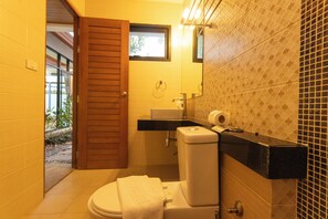Un baño pequeño con inodoro, lavamanos y una ventana.