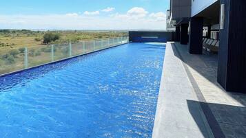 A rooftop infinity pool with a clear view of the landscape.