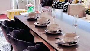 Un comedor moderno con una larga mesa dispuesta para seis personas, rodeada de sillas oscuras.