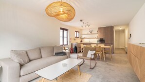 Ein modernes Wohnzimmer mit einer Couch, einem Couchtisch und einem Essbereich mit Stühlen und einem Tisch.