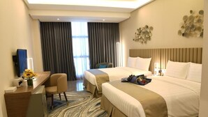 A hotel room with two beds, a desk, and a chair. There is a large window with curtains, a wall-mounted artwork, and a rug on the floor. - The Mark Hotel  (Manama)