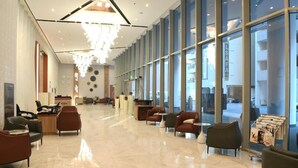 A spacious lobby with a modern chandelier, comfortable seating, and large windows offering views of the outside. - The Mark Hotel  (Manama)