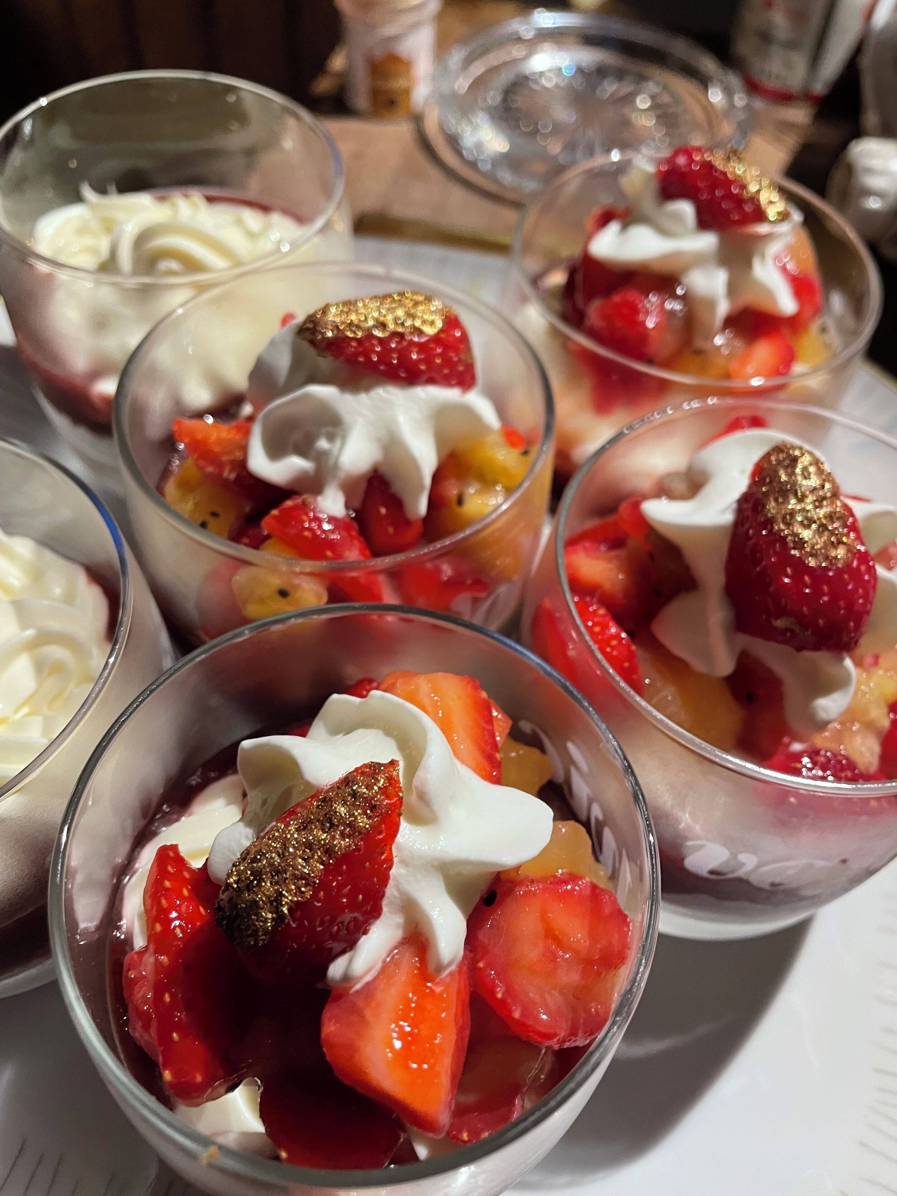 Una bandeja con porciones individuales de fruta y crema batida.