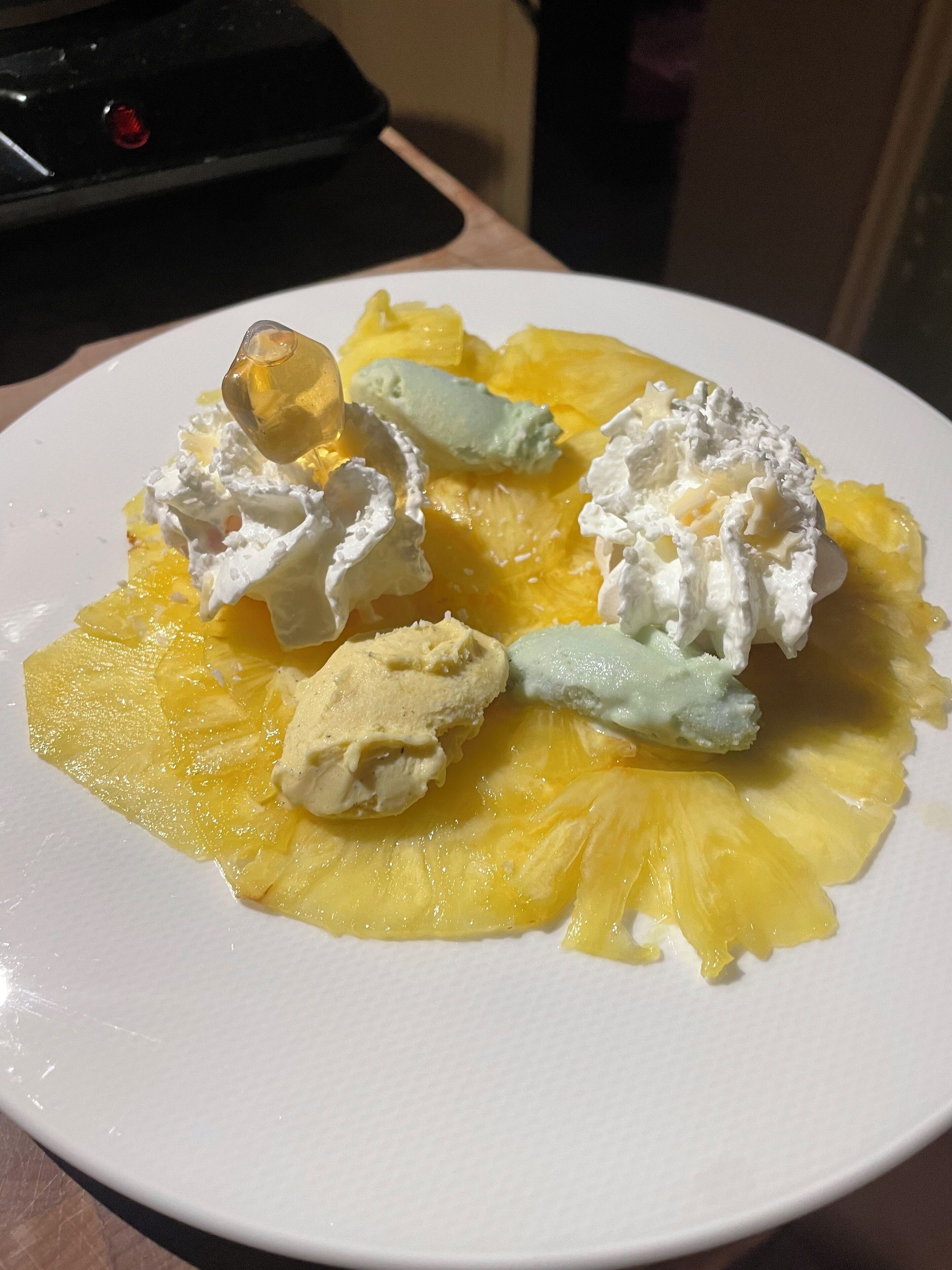 A plate with pineapple slices and whipped cream.