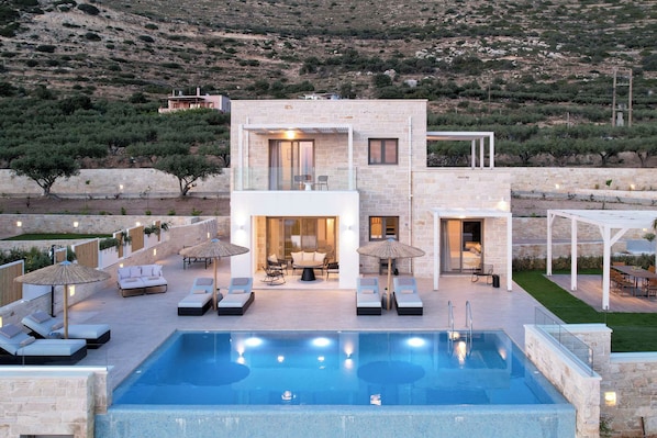 A modern two-story building with a swimming pool, outdoor seating, and a view of a hilly landscape. - Free heated pools & 800m sea (Kissamos)