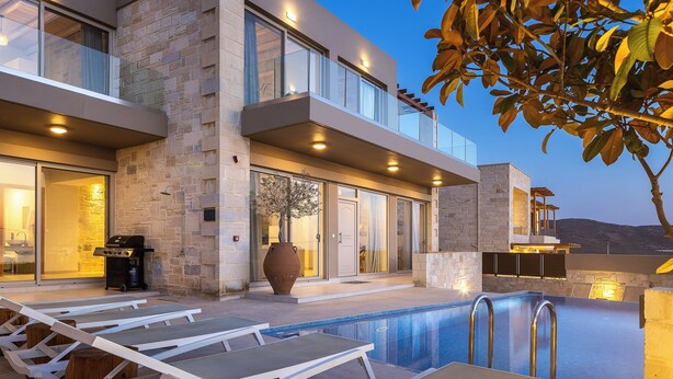 Ein modernes Haus mit Swimmingpool, Sitzgelegenheit im Freien und Grillplatz.