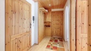 Un pasillo con puertas de madera y piso de tablones.
