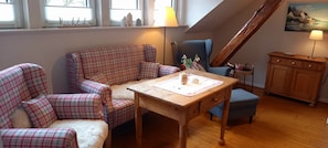 A cozy room with plaid-patterned chairs, a wooden table, and a painting on the wall. - Country Apartment "Alte Mühle" Near Biggesee (Drolshagen-Berlinghausen)