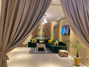 A modern living room with a green sofa, a coffee table, and a potted plant. - Villa Tounarouz a haven of peace at the gateway to Marrakech (Marrakech)