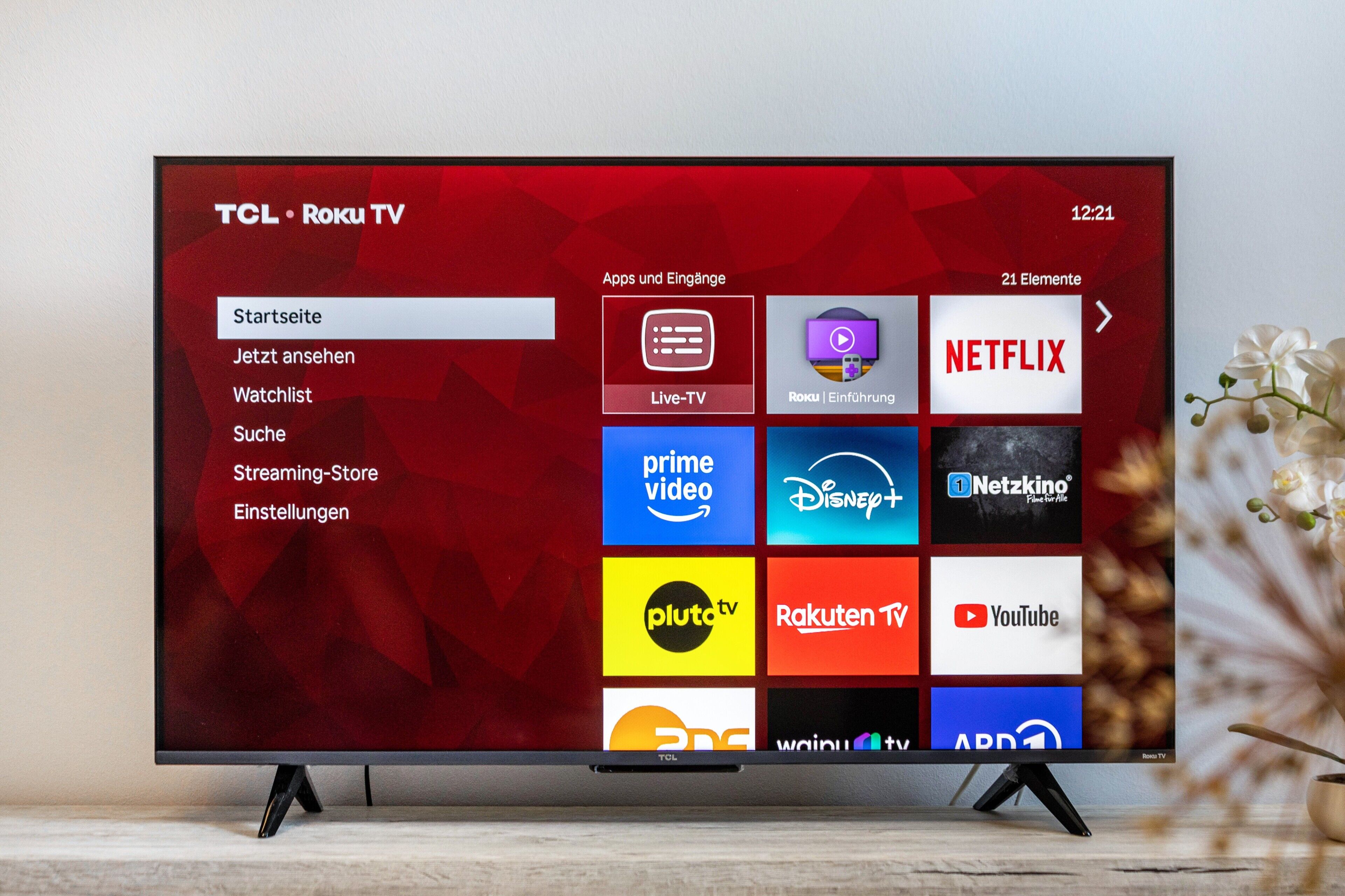 Un televisor TCL Roku con una interfaz roja que muestra diversos servicios de transmisión.