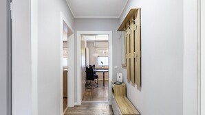 A narrow hallway with wooden flooring, a wooden bench, and a wall-mounted coat rack. - Wimbern Apartment 'Upper Floor' with Streaming, Kitchen & Laundry (Wickede (Ruhr))