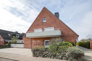 Un bâtiment en briques avec un toit en pente, un balcon et une enseigne indiquant « Huis Alice ».