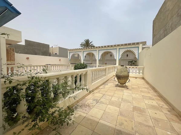 Stroll through this serene courtyard, surrounded by buildings with a modern architectural style, featuring a decorative grill and a beautiful balustrade.