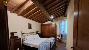 Une chambre à coucher avec un lit en bois, une table de chevet, une chaise et une armoire.