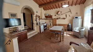 Une cuisine chaleureuse avec un coin repas, un plafond en bois et un téléviseur.