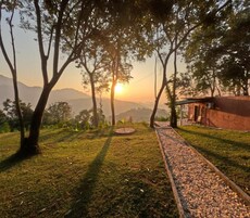 Un camino que lleva a un edificio con vistas a montañas al fondo.