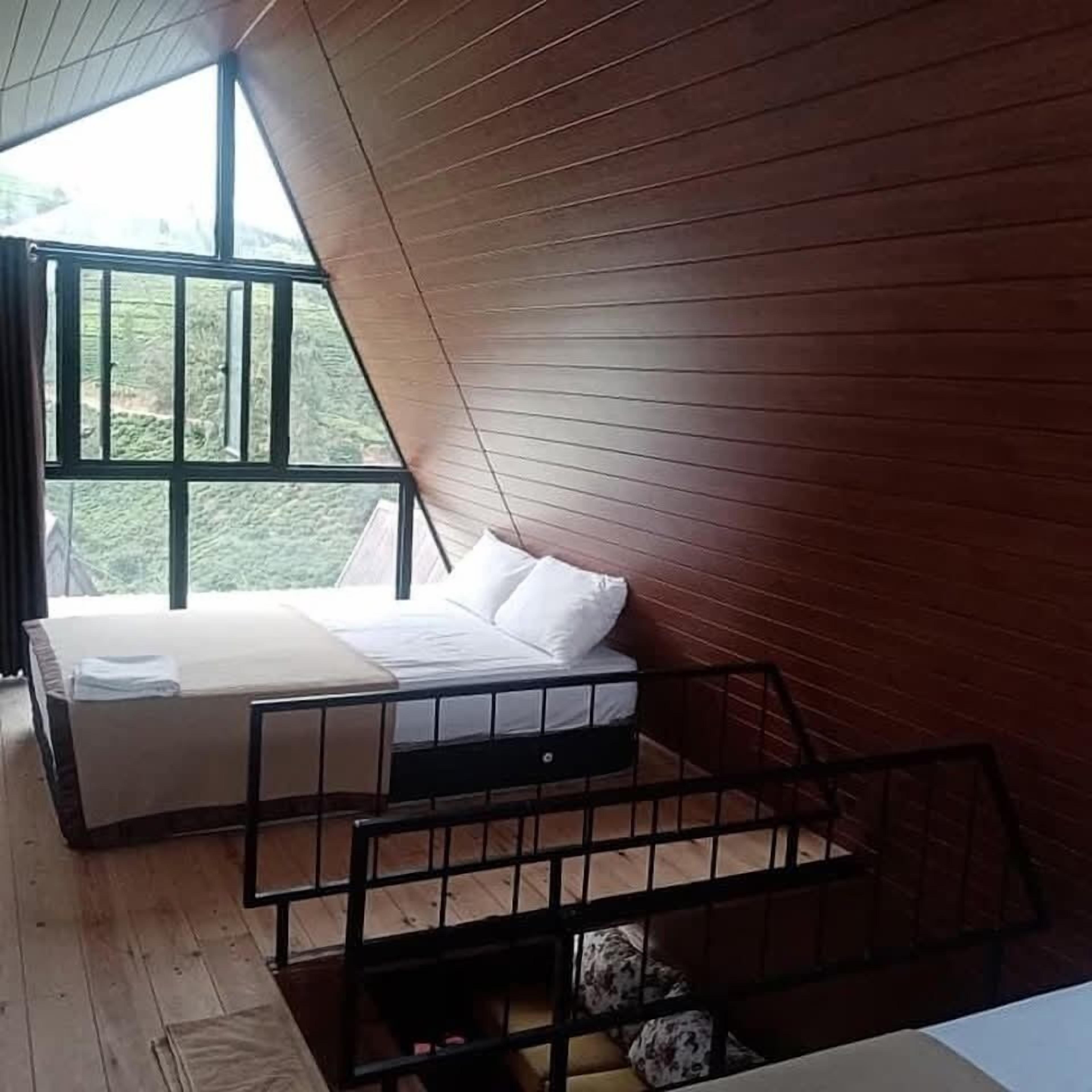 Un dormitorio con una cama, una ventana y vistas al exterior.