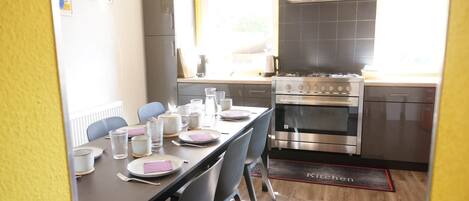 Una cucina moderna con un'area pranzo allestita per quattro persone.