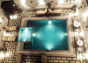 A rooftop swimming pool with a tiled deck, lounge chairs, and potted plants. - EASTERN GATE-A BERGAMONT GROUP OF HOTELS (Port Blair)