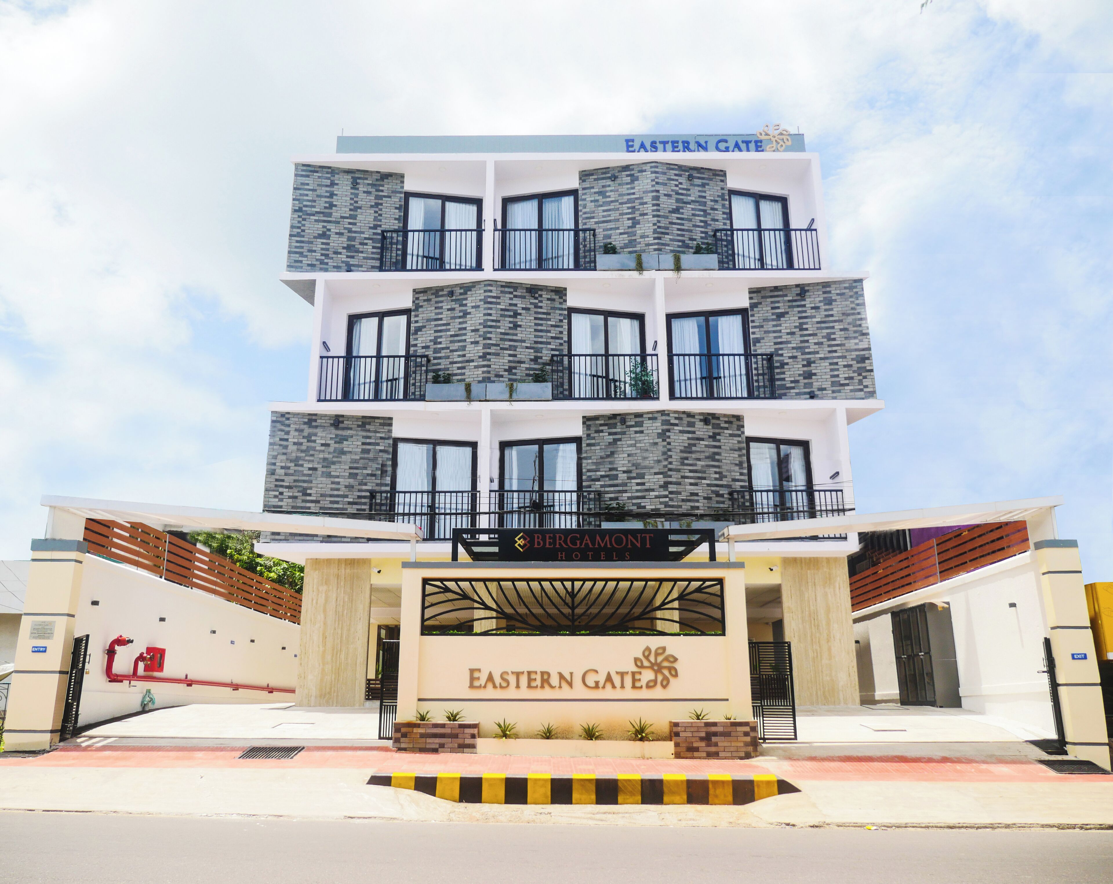 A multi-story hotel with a modern design, featuring balconies and a prominent entrance with a sign for Eastern Gate.