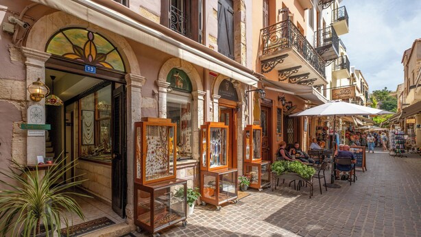 Une rue pavée bordée de boutiques et de terrasses.