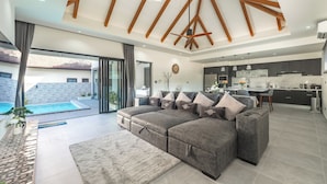 A modern living room with a sectional sofa, a dining area, and a kitchen. - Super modern Brand new Beautiful V162 (Rawai)