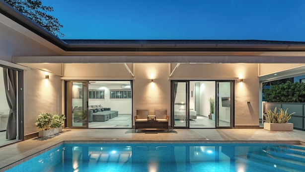 A modern pool area with a clear view of the adjacent living room, large windows, and a well-lit interior. - Super modern Brand new Beautiful V162 (Rawai)