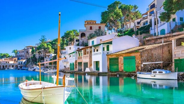 A coastal village with traditional buildings, a clear blue harbor, and boats moored at the dock. - Villa flamingo súper lujo (Llucmajor)