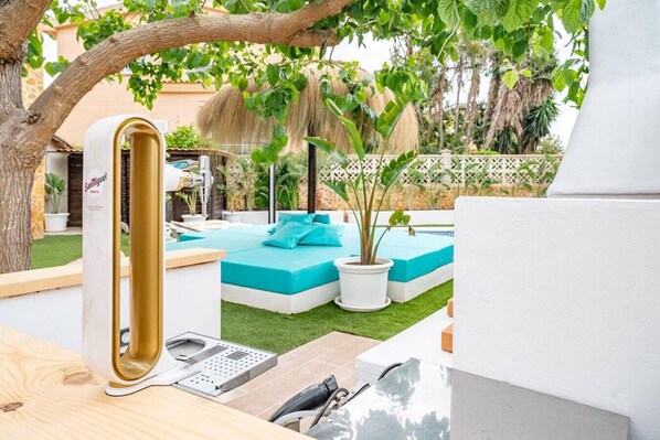 A modern outdoor pool area with a built-in sauna, a small seating area, and a well-maintained lawn. - Villa flamingo súper lujo (Llucmajor)