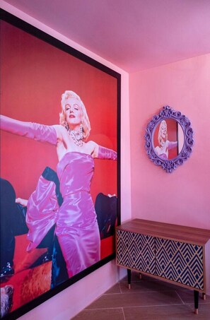 A room with a large framed picture of a person in a pink dress, a mirror with an ornate frame, and a patterned wooden cabinet. - Villa flamingo súper lujo (Llucmajor)